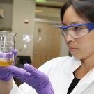 Photo: Selina Wang, Olive Center research director, holding a beaker