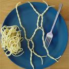 Photo: fork with twisted spaghetti on blue plate