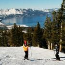 Photo: skiers on slope with Tahoe in the distance