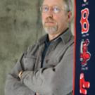 Historian Alan Taylor stands next to a Boston Red Sox banner (he is a Sox fan). Each spring Taylor helps graduate students organize a weekly game of town ball, an early 19th century baseball-style game that he learned about while doing research 