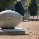 The Bookhead Egghead sculpture with the library plaza in the background on a sunny day.