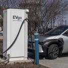 White EVgo charging station with grey electric vehicle charging. (Getty)