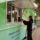 A student picks up a meal from a green food truck