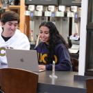 Two students look at the screen of a laptop in the Coffee House.