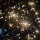 A field of stars and galaxies, some distorted in shape.